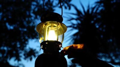 Light an Illuminating Kerosene lamp with a match, close-up of a hand lighting.