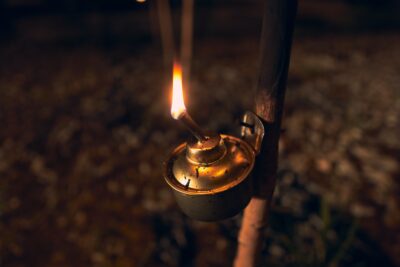 Light an oil lamp with a match, close-up of a hand lighting an old oil lamp.